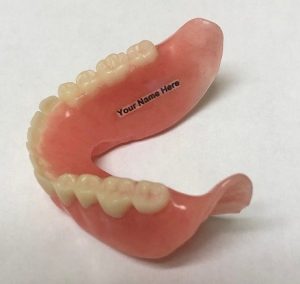 a persons name is placed on a denture to identify the owner of the denture when lost